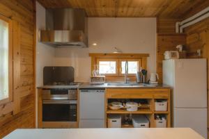 a kitchen with a stove and a refrigerator at The Lodge 弟子屈 in Teshikaga