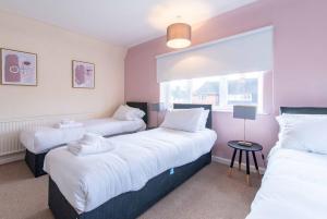 a bedroom with two beds with white sheets and a window at Your Nottingham Haven - 3 Bed House with Free Wifi and Parking in Nottingham