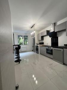 a large kitchen with white tile floors and appliances at Appartement Marseille - Le Canet in Marseille