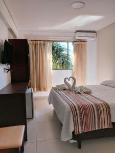 1 dormitorio con cama y ventana en Hotel Castelo Branco en Foz de Iguazú