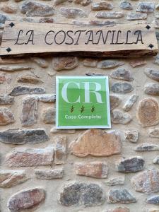 una señal en el costado de una pared de piedra en Casa Rural LA COSTANILLA en Lituénigo