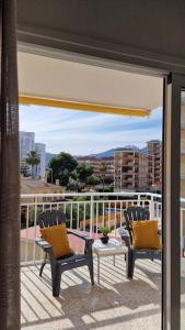 two chairs and a table on a balcony with a view at Apartamento de playa en paseo marítimo in Benicàssim
