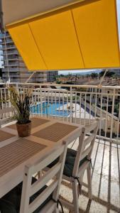 a table with a yellow umbrella on a balcony at Apartamento de playa en paseo marítimo in Benicàssim