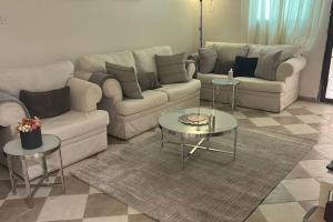 a living room with a couch and two tables at Riyadh, King Faisal District Apartment in Riyadh +2 photos