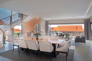 a dining room with a table and chairs at Luxury Zimbali Villa*7 Grandview*Seaview*Pool* in Ballito