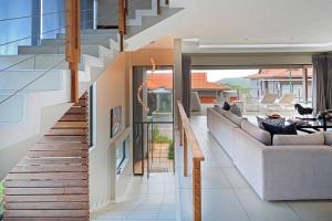a living room with a staircase in a house at Luxury Zimbali Villa*7 Grandview*Seaview*Pool* in Ballito