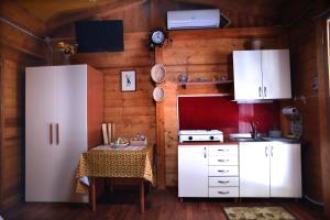 Rogliano的住宿－CHALET NEL BOSCO - TENUTA BOCCHINERI，厨房配有白色冰箱和桌子