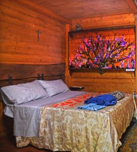a bedroom with a bed in a wooden cabin at CHALET NEL BOSCO - TENUTA BOCCHINERI in Rogliano