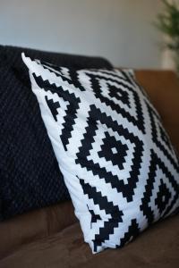 ein schwarzes und weißes Kissen auf einer Couch in der Unterkunft Keir Hardie House in Larkhall
