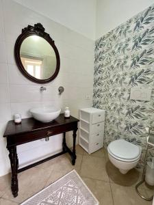 y baño con lavabo, aseo y espejo. en LA CASA DEL MOSAICO, en Angri
