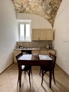 cocina con mesa y sillas en una habitación en LA CASA DEL MOSAICO, en Angri