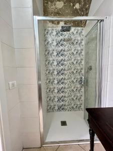 y baño con ducha y puerta de cristal. en LA CASA DEL MOSAICO, en Angri