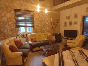 a living room with yellow couches and a television at Villa Stella in Florina