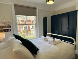 - une chambre avec un lit blanc avec des oreillers et une fenêtre dans l'établissement Home in Dartmouth, Devon with Private Parking, à Dartmouth