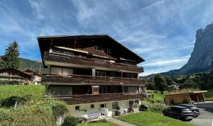 ein großes Gebäude mit einem davor geparkt in der Unterkunft Chalet Ribi in Grindelwald