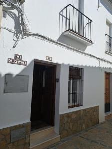Edificio blanco con puerta y balcón en La Gonzala, en Zahara de la Sierra