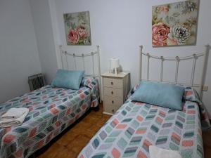 ein Schlafzimmer mit 2 Betten und eine Kommode mit einem Nachttisch in der Unterkunft La Gonzala in Zahara de la Sierra
