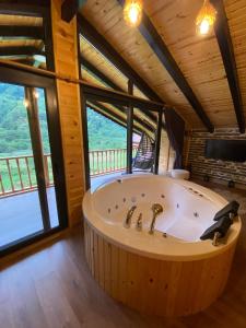 a large tub in a room with large windows at Hayvore Loft in Çamlıhemşin