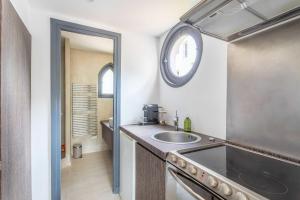 une cuisine avec un évier et une horloge murale dans l'établissement Small private house 4P1BR - Marseille 8th, à Marseille