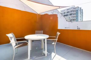 a white table and chairs in a room at Studio 9 Pinheiros by OBA in São Paulo