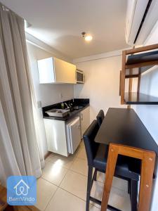 a small kitchen with a black table and chairs in a room at Apartamento em frente ao Salvador Shopping in Salvador