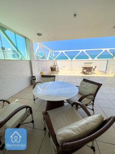 a table and chairs with a view of the ocean at Apartamento em frente ao Salvador Shopping in Salvador