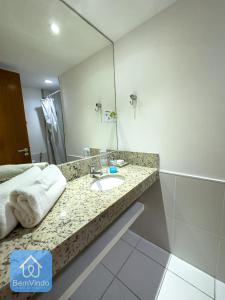 a bathroom with a sink and a mirror at Apartamento em frente ao Salvador Shopping in Salvador