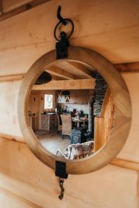 a round mirror on a wall with a room at Górskie Tarasy in Rabka