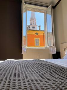 sypialnia z oknem z widokiem na budynek w obiekcie Duomo 12 w mieście Modena