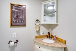 ein Bad mit einem Waschbecken und einem Spiegel in der Unterkunft Vickery Cottage on Sandusky Bay with Fire Pit! in Port Clinton
