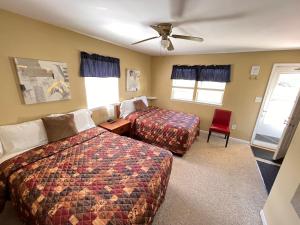 a hotel room with two beds and a ceiling fan at Honor Motel in Honor