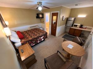 Piccola camera d'albergo con letto e tavolo di Honor Motel a Honor
