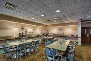 a restaurant with tables and chairs and a bar at Medallion Inn and Suites in Arlington