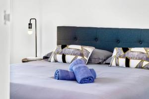 a bed with a blue towel on top of it at New Amazing Park City high level APT in Sydney