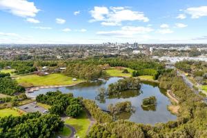 una vista aerea su un parco con un lago e una città di New Amazing Park City high level APT a Sydney