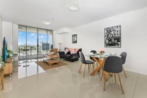 a living room with a table and a couch at Spacious 2 beds Apt near Airport in Sydney