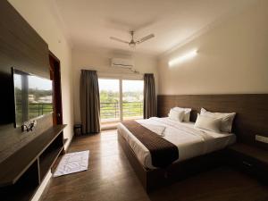 a bedroom with a bed and a large window at Hotel Elite by Agira- Spacious Apartments with Balcony in Yelahanka