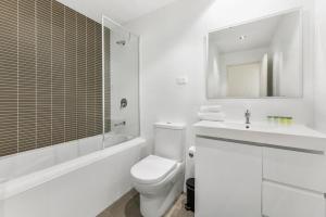 a white bathroom with a toilet and a sink at Spacious 2 beds Apt near Airport in Sydney
