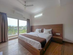 a bedroom with a large bed and a large window at Hotel Elite by Agira- Spacious Apartments with Balcony in Yelahanka