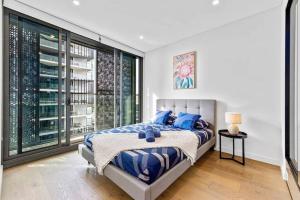 - une chambre avec un lit et une grande fenêtre dans l'établissement Luxury 2BR APT in heart of Macquarie Park, à Sydney