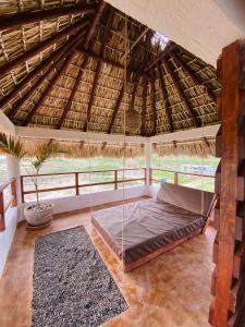 1 dormitorio con 1 cama bajo un techo de paja en Sunset Beachside Villa, en Puerto Escondido
