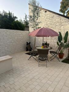 a patio with a table and chairs and an umbrella at LE JEAN JAURÈS Arrivée Autonome in Vierzon