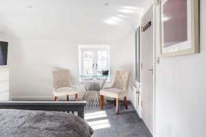a bedroom with a bed and two chairs and a table at The Secret, Stylish & Spacious En Suite in Blandford Forum, Dorset in Blandford Forum