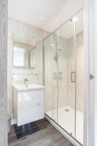 y baño con ducha, lavabo y bañera. en The Secret, Stylish & Spacious En Suite in Blandford Forum, Dorset, en Blandford Forum