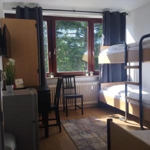 een slaapkamer met een stapelbed, een bureau en een stoel bij Monteurzimmer in Hamburg West bei Hansezimmer in Hamburg