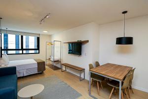 Zimmer mit einem Bett und einem Esszimmer mit einem Tisch in der Unterkunft 360 Rio Santos Dumont in Rio de Janeiro