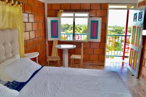 Schlafzimmer mit einem Bett, einem Tisch und Fenstern in der Unterkunft Casa del Bosque in Trujillo