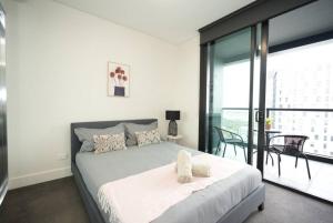 a bedroom with a bed with two stuffed animals on it at Superior View APT in heart of Sydney Olympic Park in Sydney