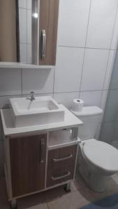 La salle de bains est pourvue d'un lavabo et de toilettes. dans l'établissement Suites Vista Do Parque, à Penha