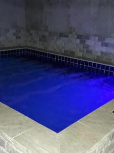 a large blue swimming pool with a tiled floor at Casa do Beto in Pirenópolis